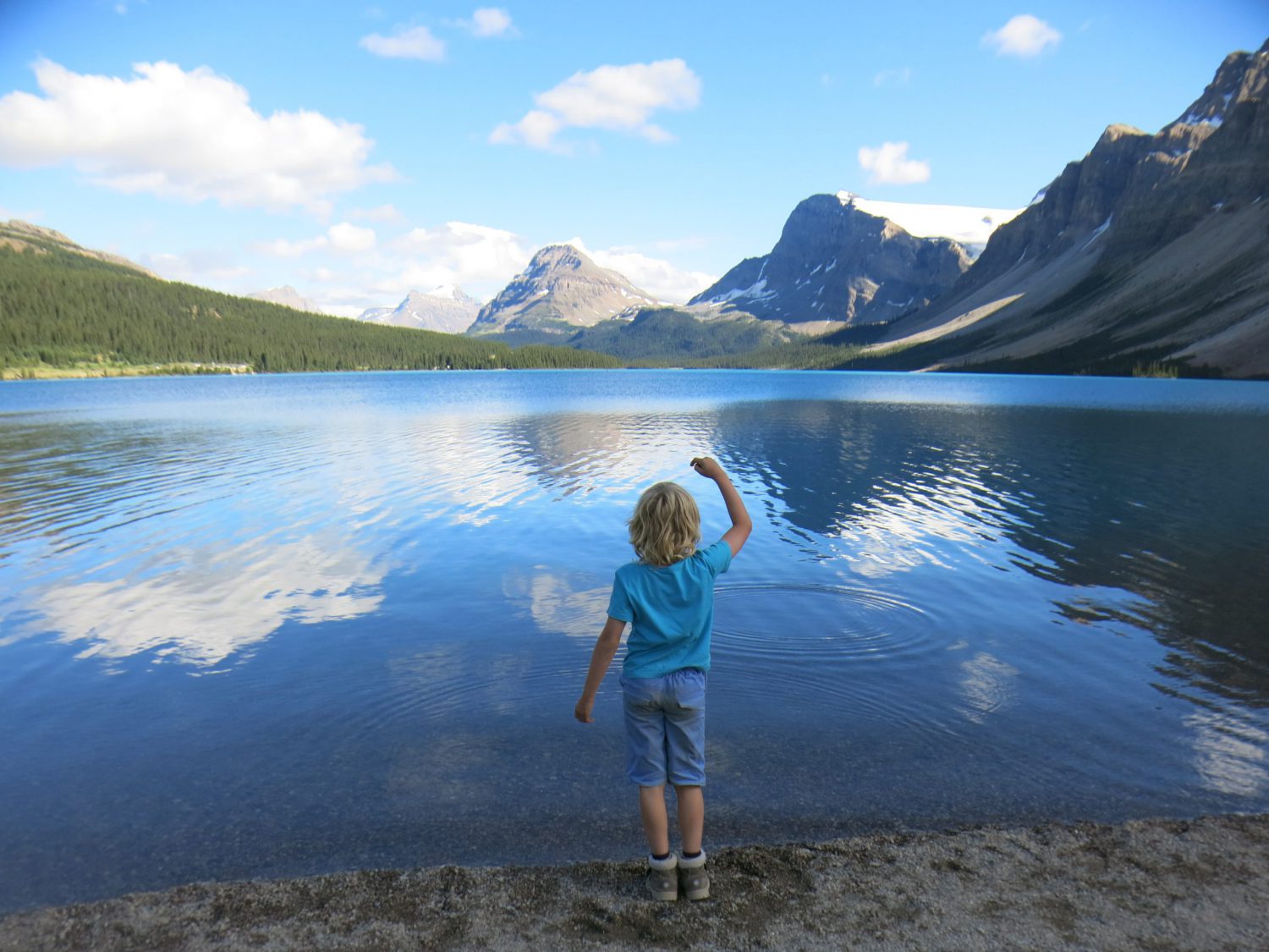 Boy throwing stones into lake, Canada pictures