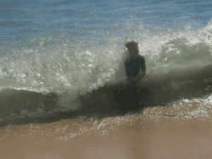 Boy in waves, Sagres, Portugal, travel tales