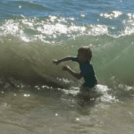 Boy in waves, Sagres, Portugal, travel tales