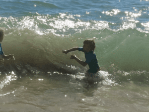 Boy in waves, Sagres, Portugal, travel tales