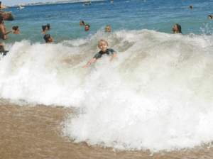 Boy in waves, Lagos, Portugal, travel tales