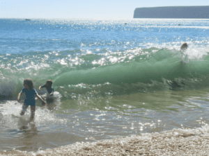 Boy in waves, Sagres, Portugal, travel tales